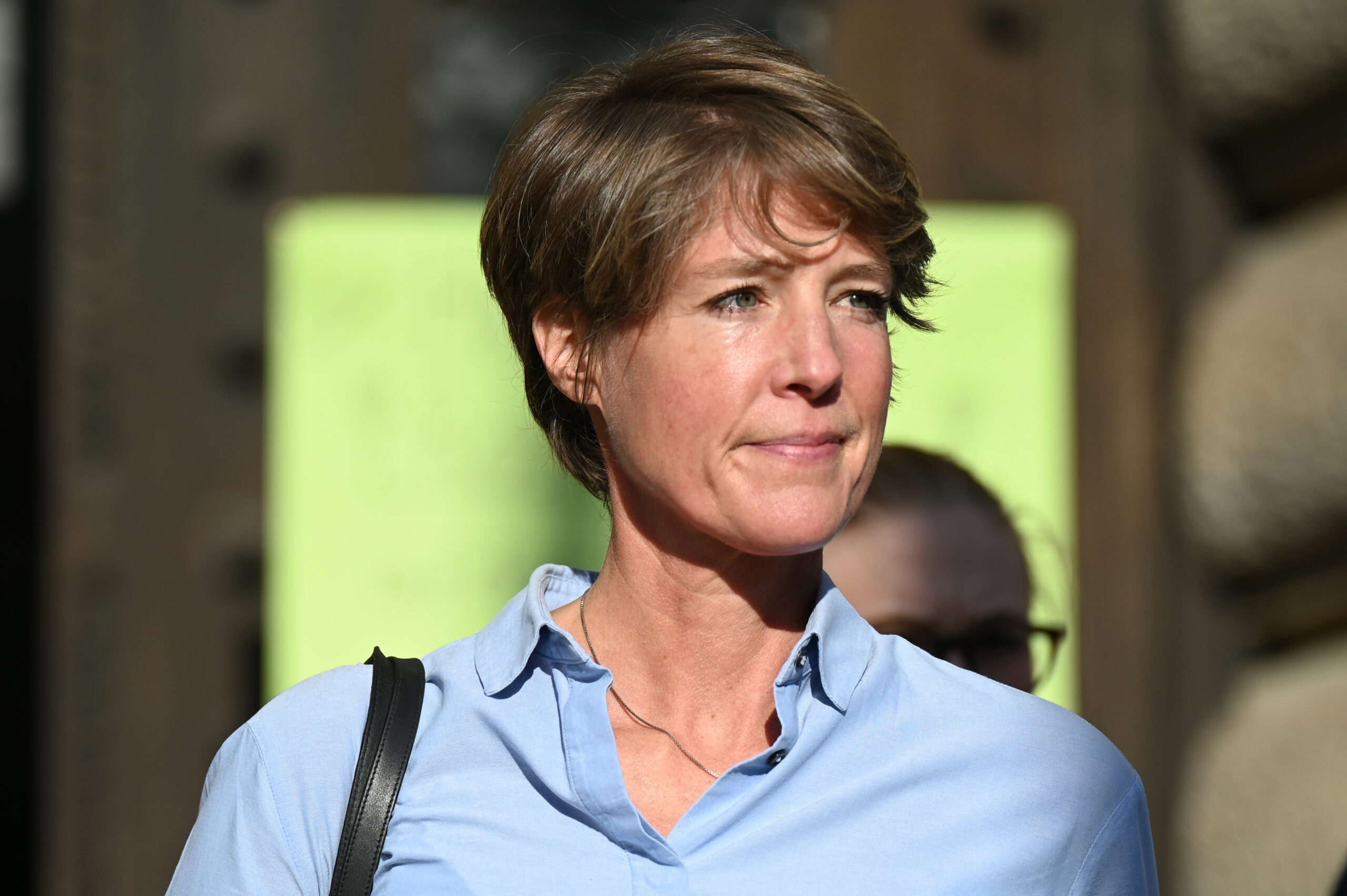 Frau in hellblauer Bluse und kurzem Haar