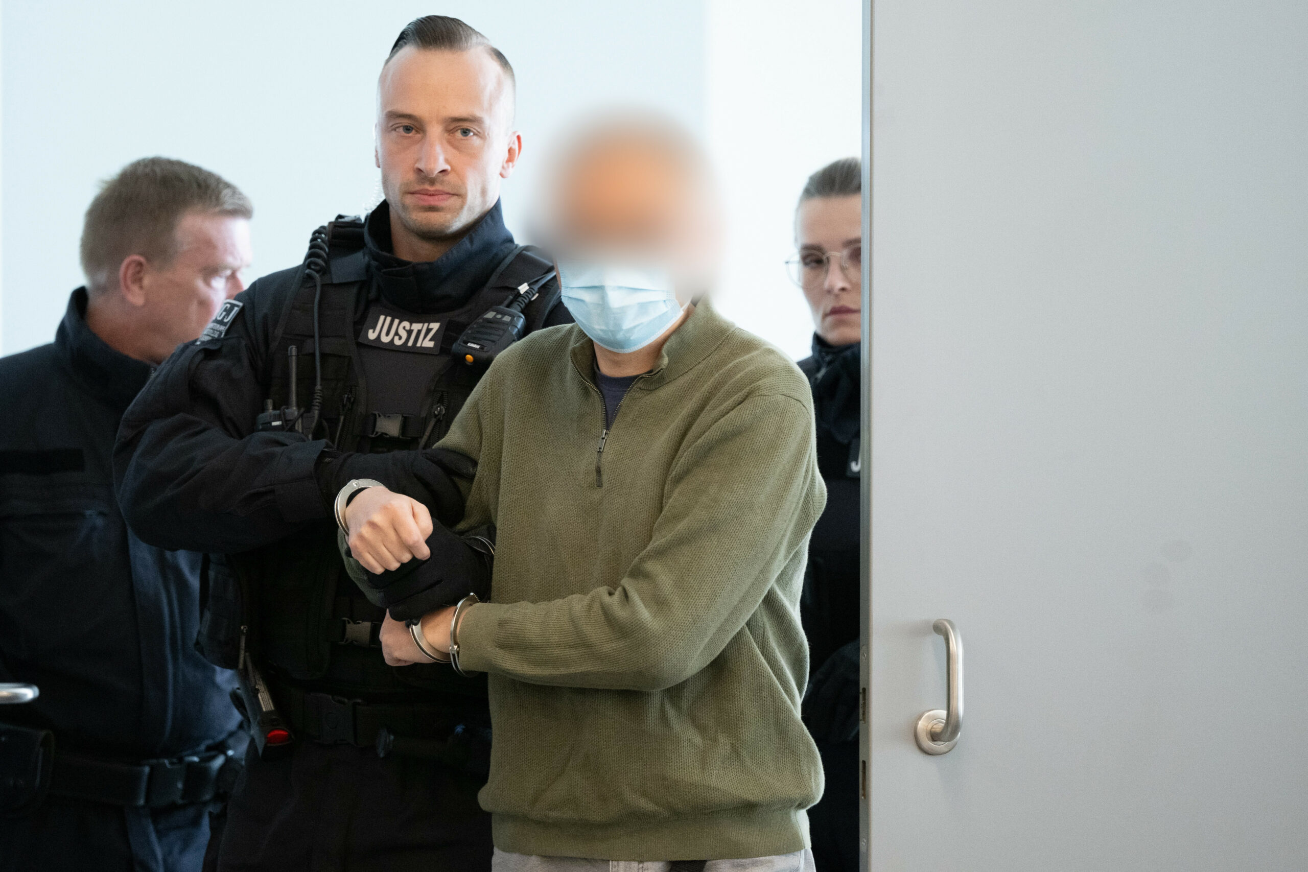 Der Hauptangeklagte Jian G. wird vor Prozessbeginn in den Gerichtssaal geführt