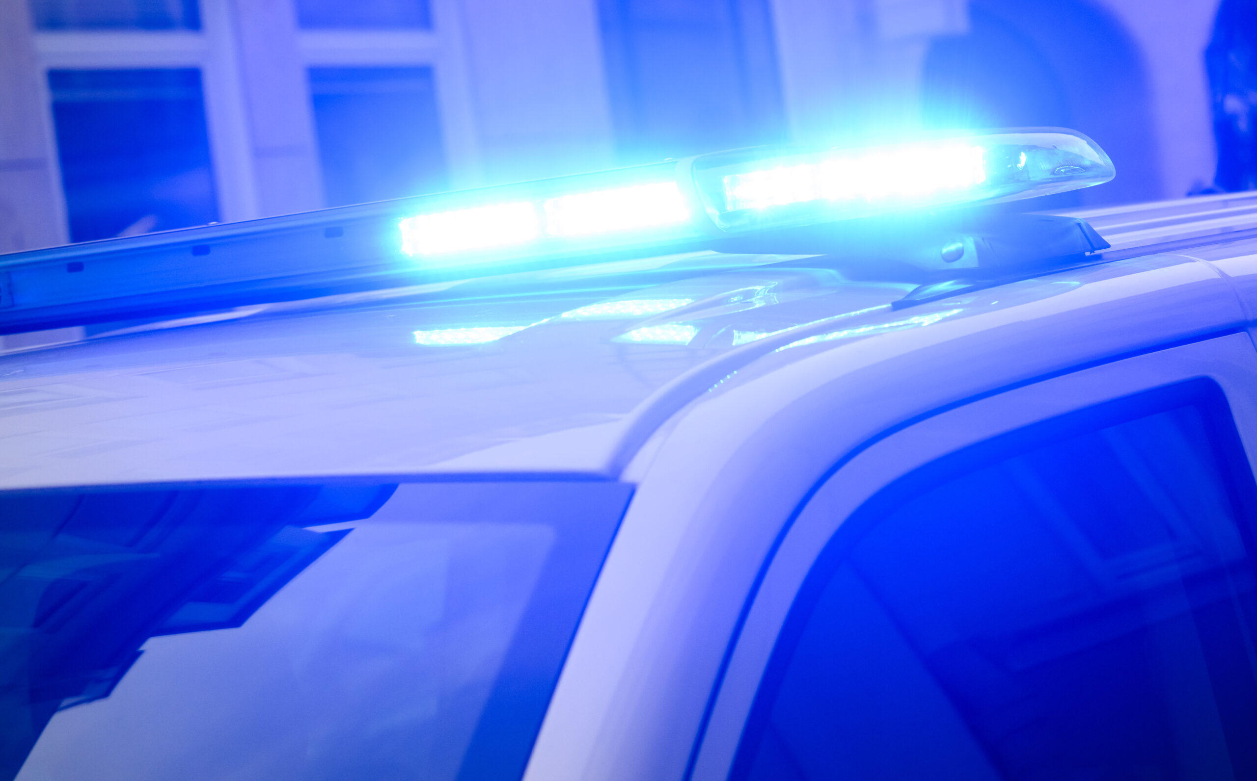 Ein Blaulicht leuchtet auf einem Einsatzfahrzeug der Polizei.