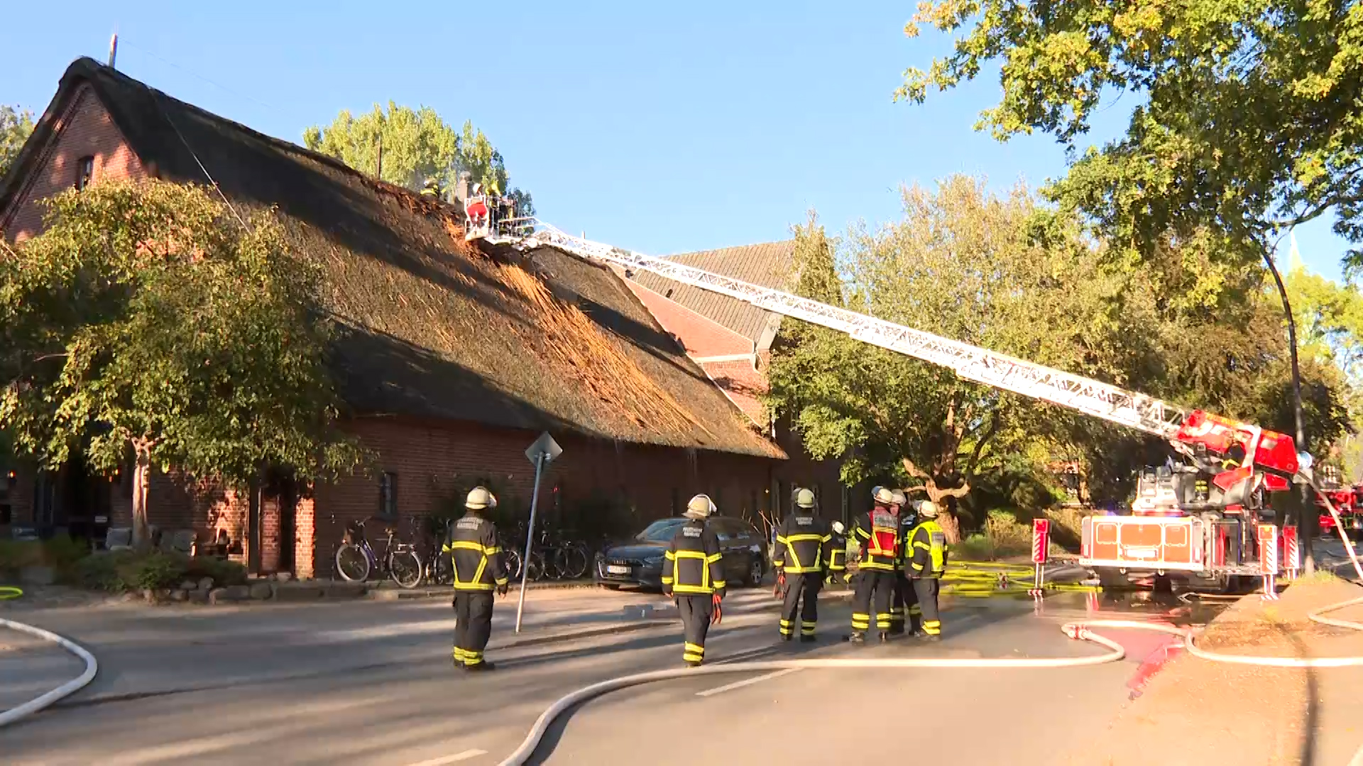 Feuerwehrleute stehen mit einem Krahn an dem Hotel.