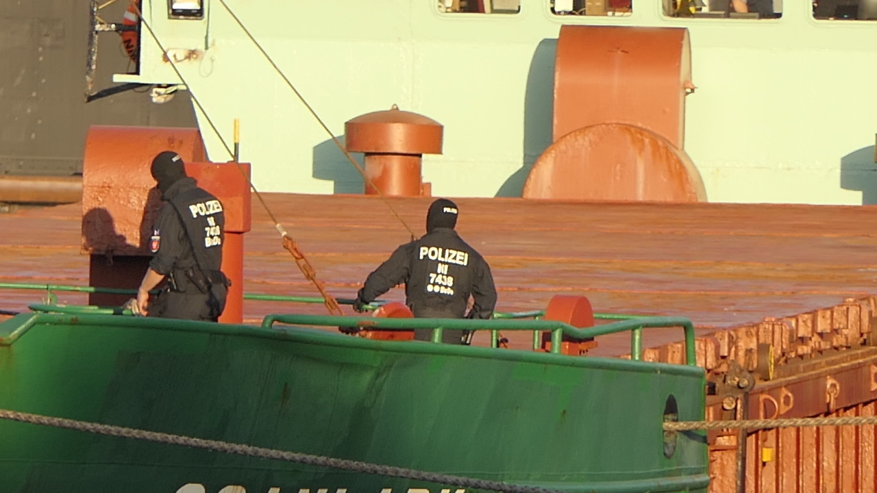 Maskierte Polizeikräfte an Bord der „Scanlark“ auf dem Nord-Ostsee-Kanal in Kiel.