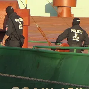 Maskierte Polizeikräfte an Bord der „Scanlark“ auf dem Nord-Ostsee-Kanal in Kiel.