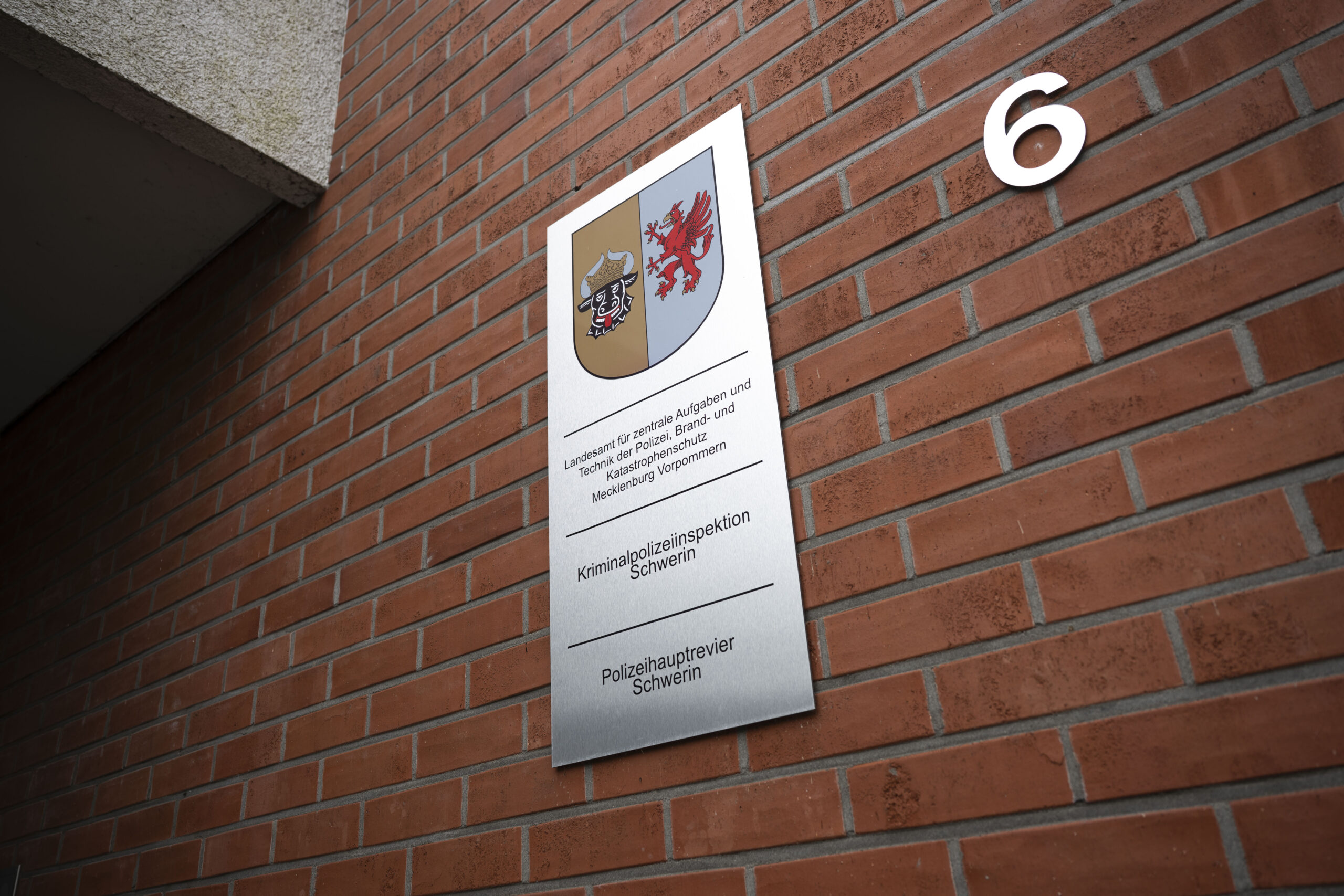Ein Schild an einer Hauswand weist auf das Landesamt für zentrale Aufgaben und Technik der Polizei, Brand- und Katastrophenschutz Mecklenburg-Vorpommern hin.