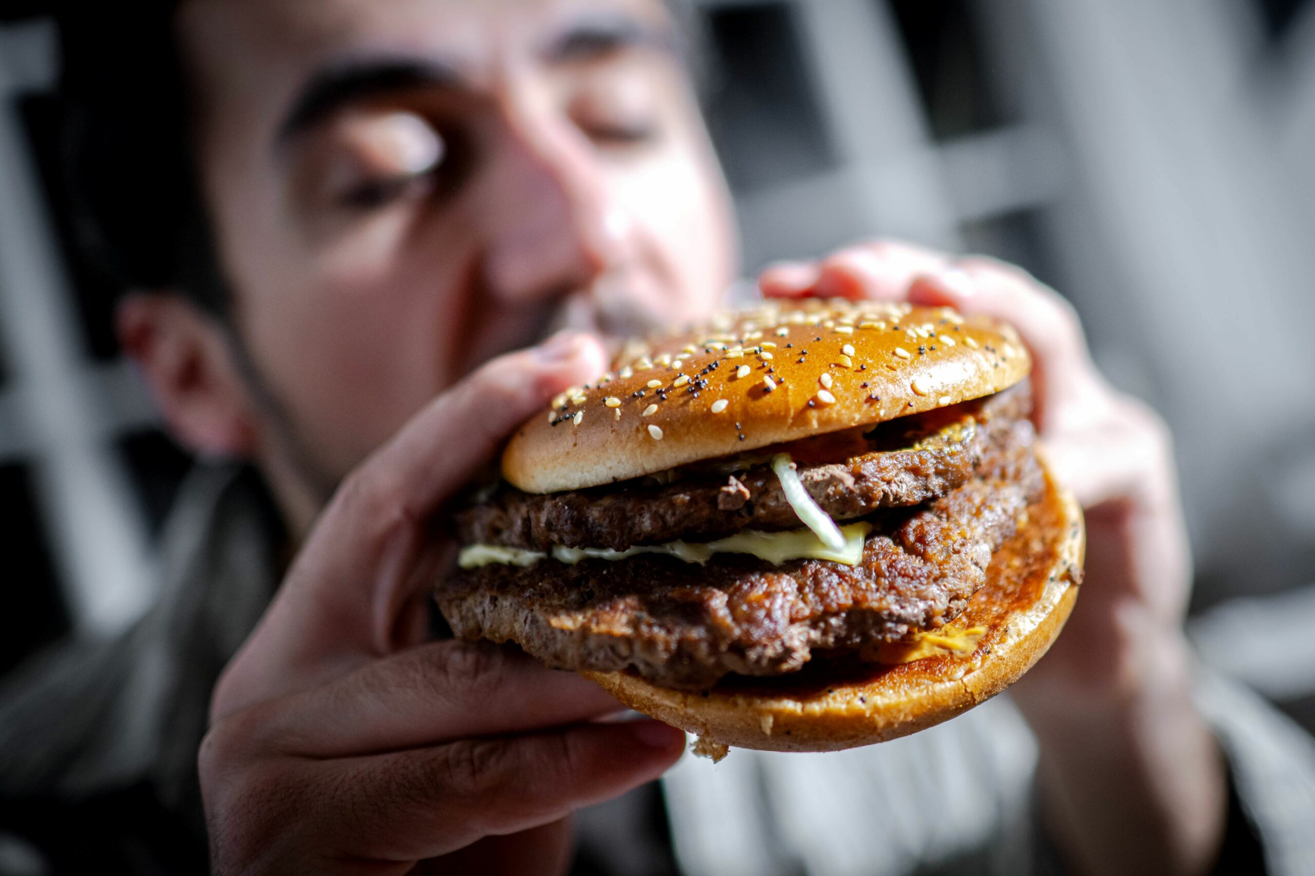 Ein Mann beißt in einen Burger.