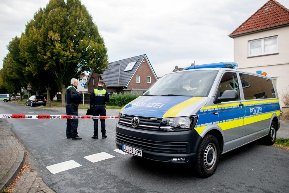 Polizisten stehen an der Absperrung rund um den Tatort in Oldenburg.