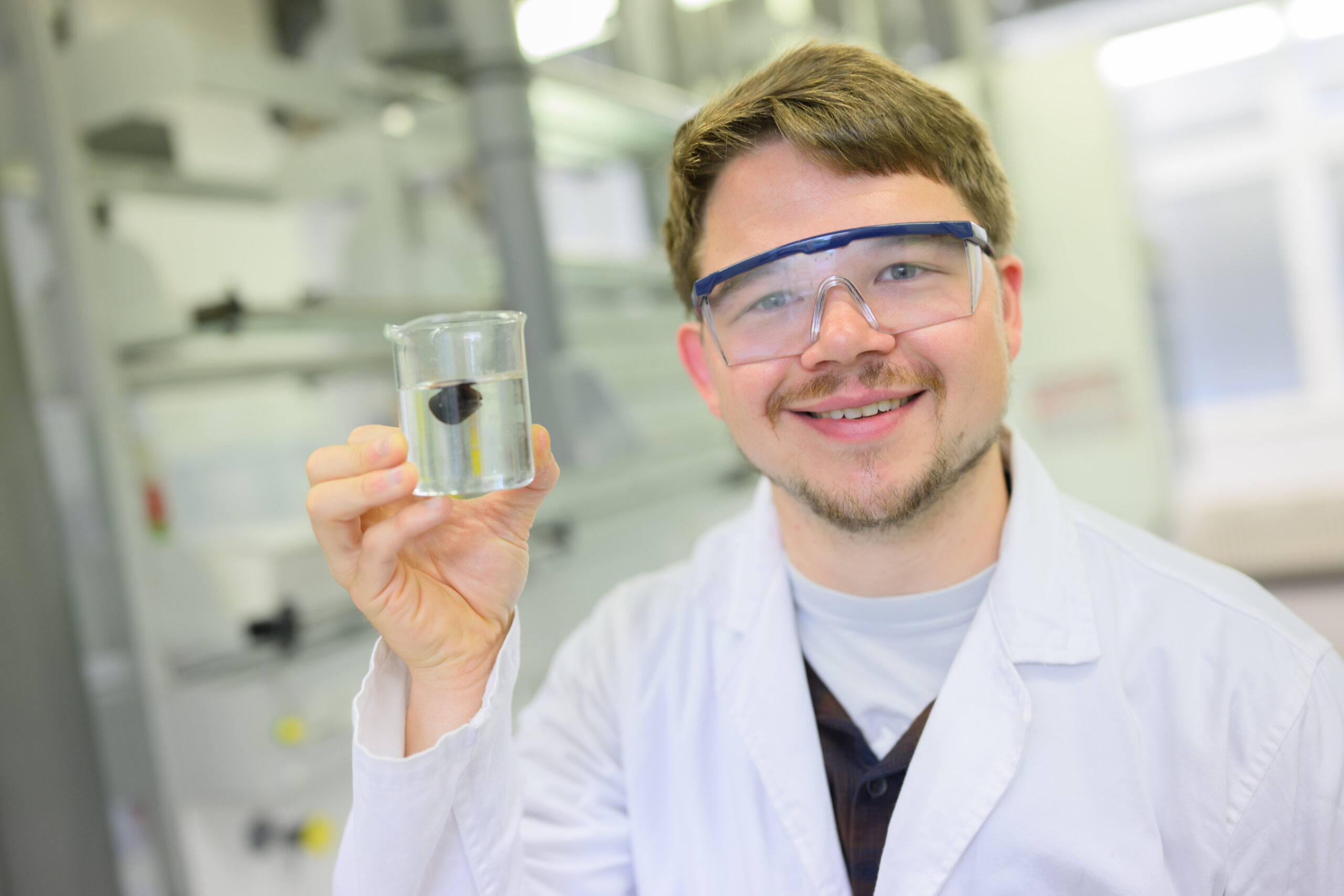Dennis Kollofrath, wissenschaftlicher Mitarbeiter am Institut für Anorganische Chemie, zeigt ein Hydrogel in einem Reagenzglas.