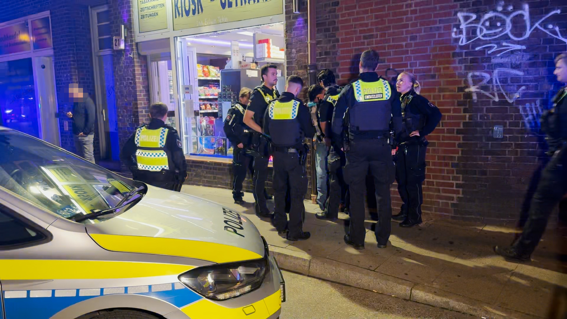 Gruppe von Polizisten vor einem Kiosk