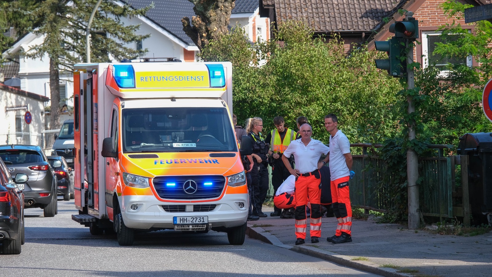 Sanitäter knien vor der Frau auf dem Gehweg