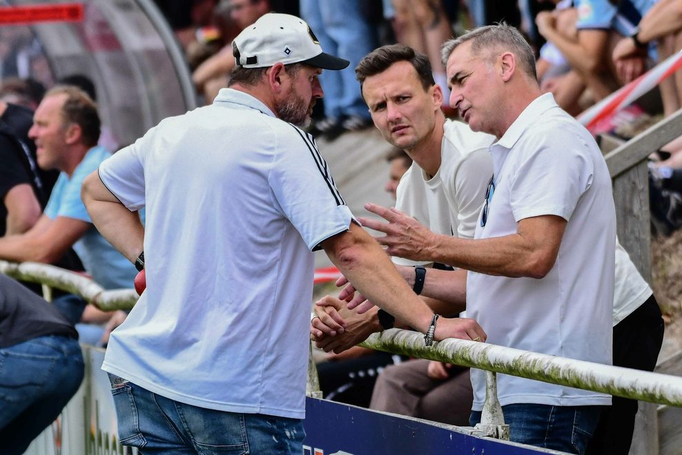Steffen Baumgart, Claus Costa und Stefan Kuntz am Spielfeldrand im Gespräch