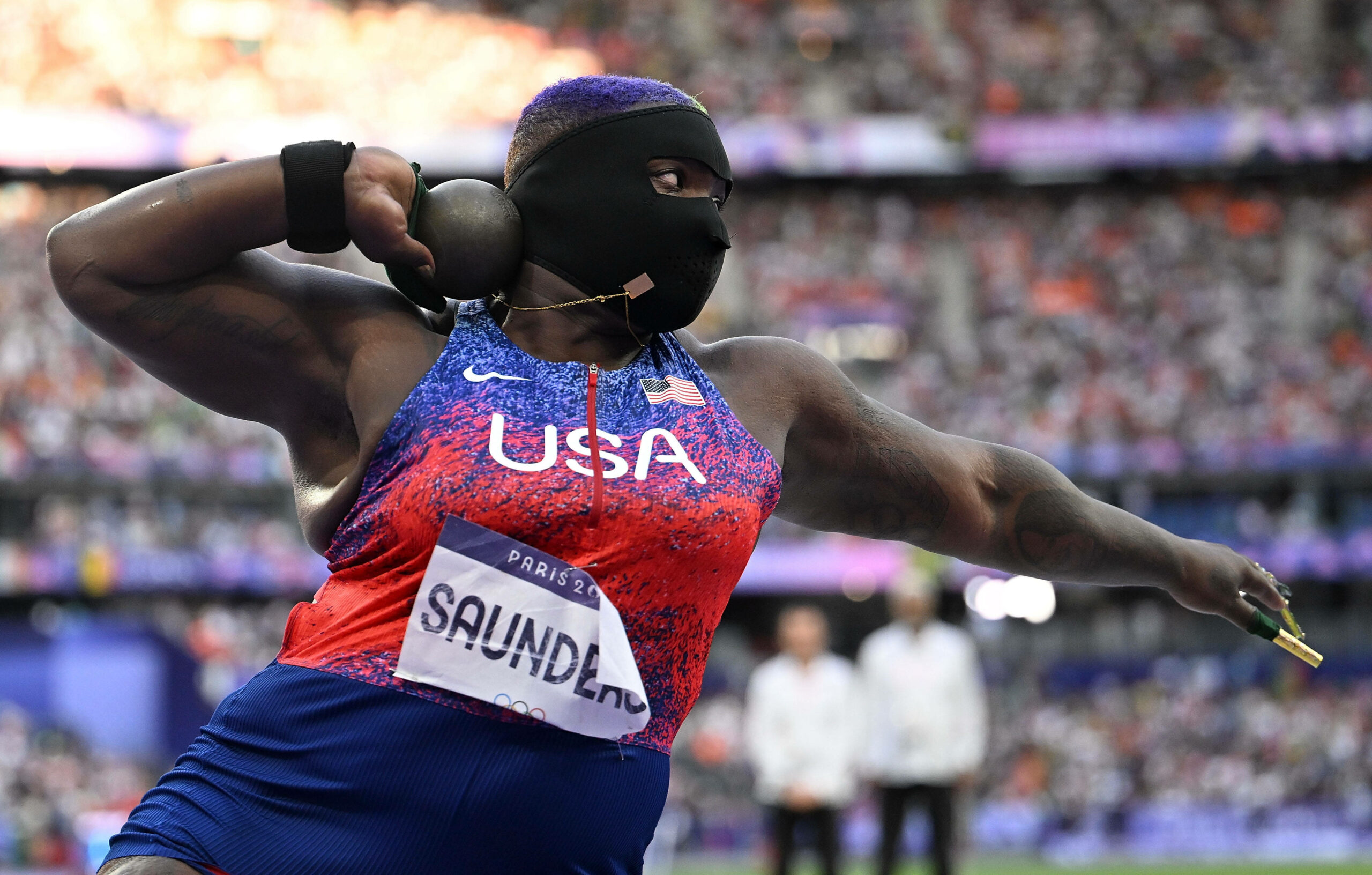 Raven Saunders beim Kugelstoßen mit schwarzer Maske.