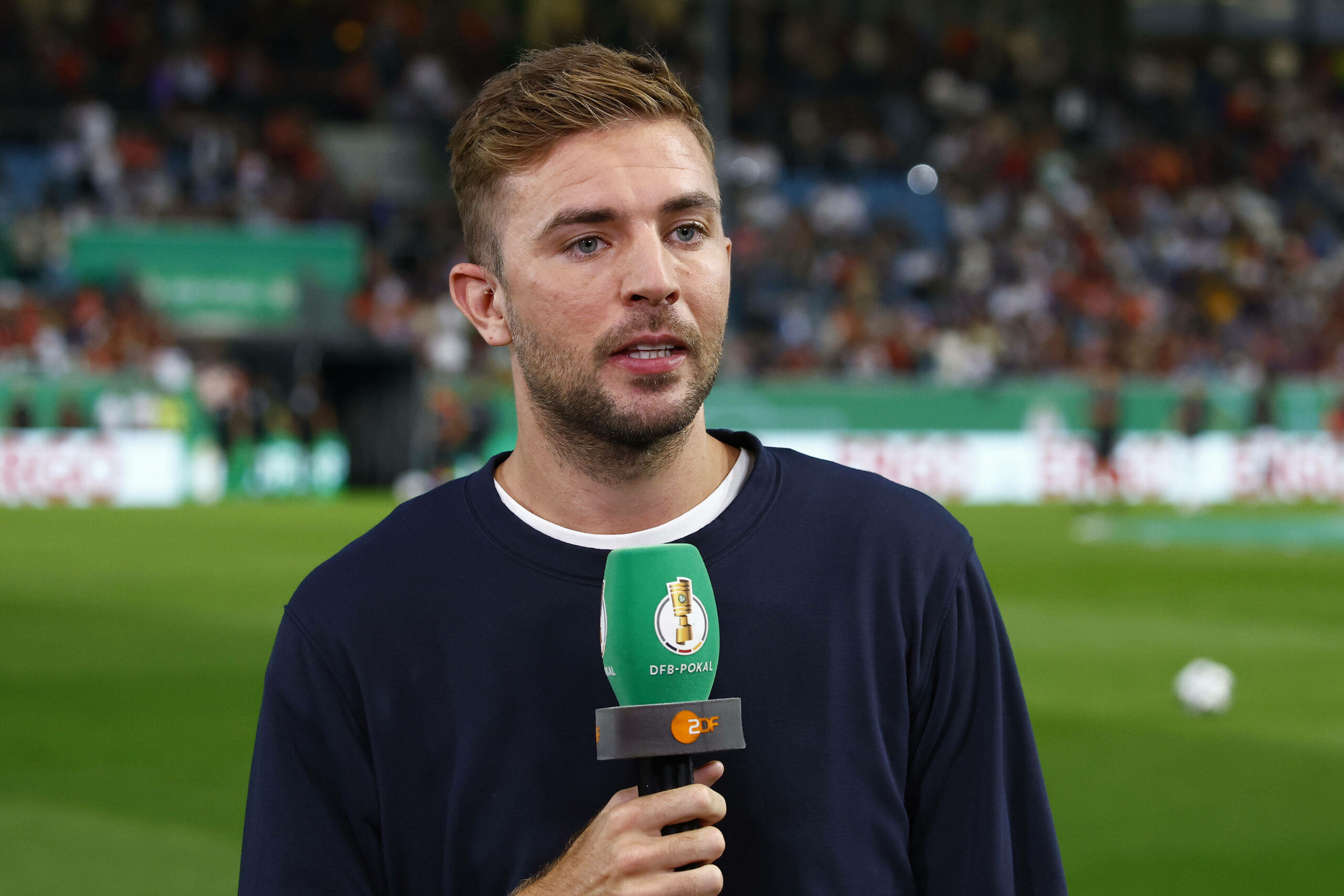 Christoph Kramer als ZDF-Experte beim DFB-Pokal mit Mikrofon in der Hand