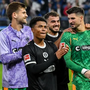 Ben Voll, Joel Chima Fujita, Danel Sinani, Nikola Vasilj und Connor Metcalfe freuen sich vor der Fankurve