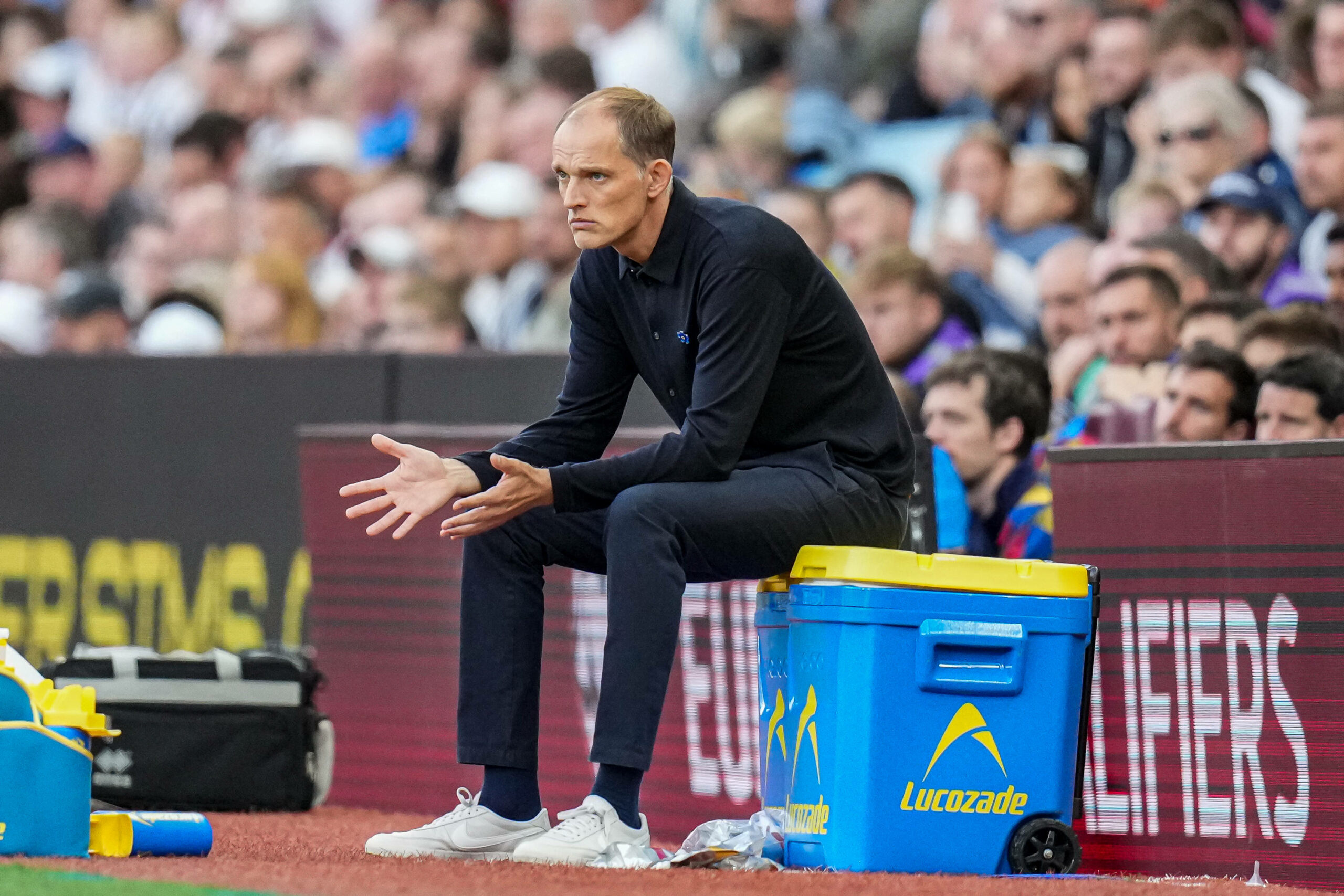 Thomas Tuchel sitzt vor einer Werbebande