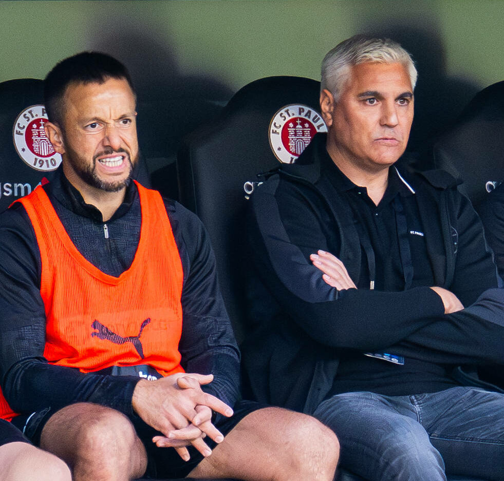 Athletiktrainer Karim Rashwan auf der Bank neben Sportchef Andreas Bornemann