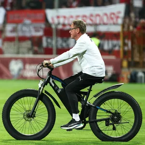 Rangnick mit E-Bike auf Stadionrasen.