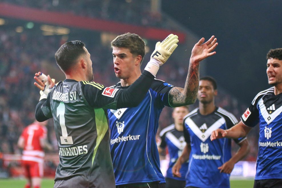 Luka Vuskovic klatscht mit HSV-Keeper Daniel Heuer Fernandes nach dessen gehaltenem Elfmeter ab