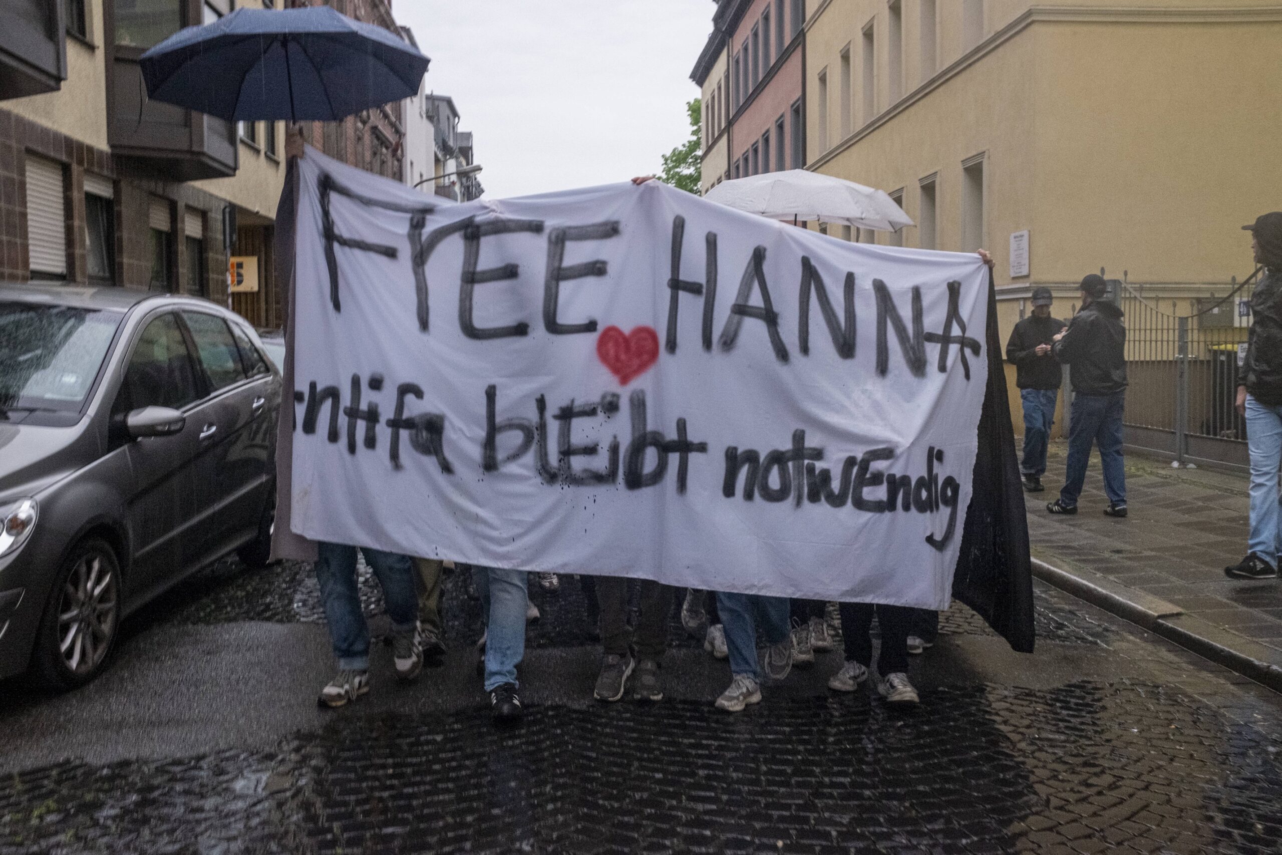 Demonstranten halten ein Schild mit der Aufschrift „Free Hanna, Antifa bleibt notwendig“ hoch.