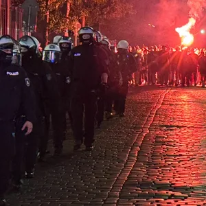 Polizei mit Pyrotechnik im Hintergrund