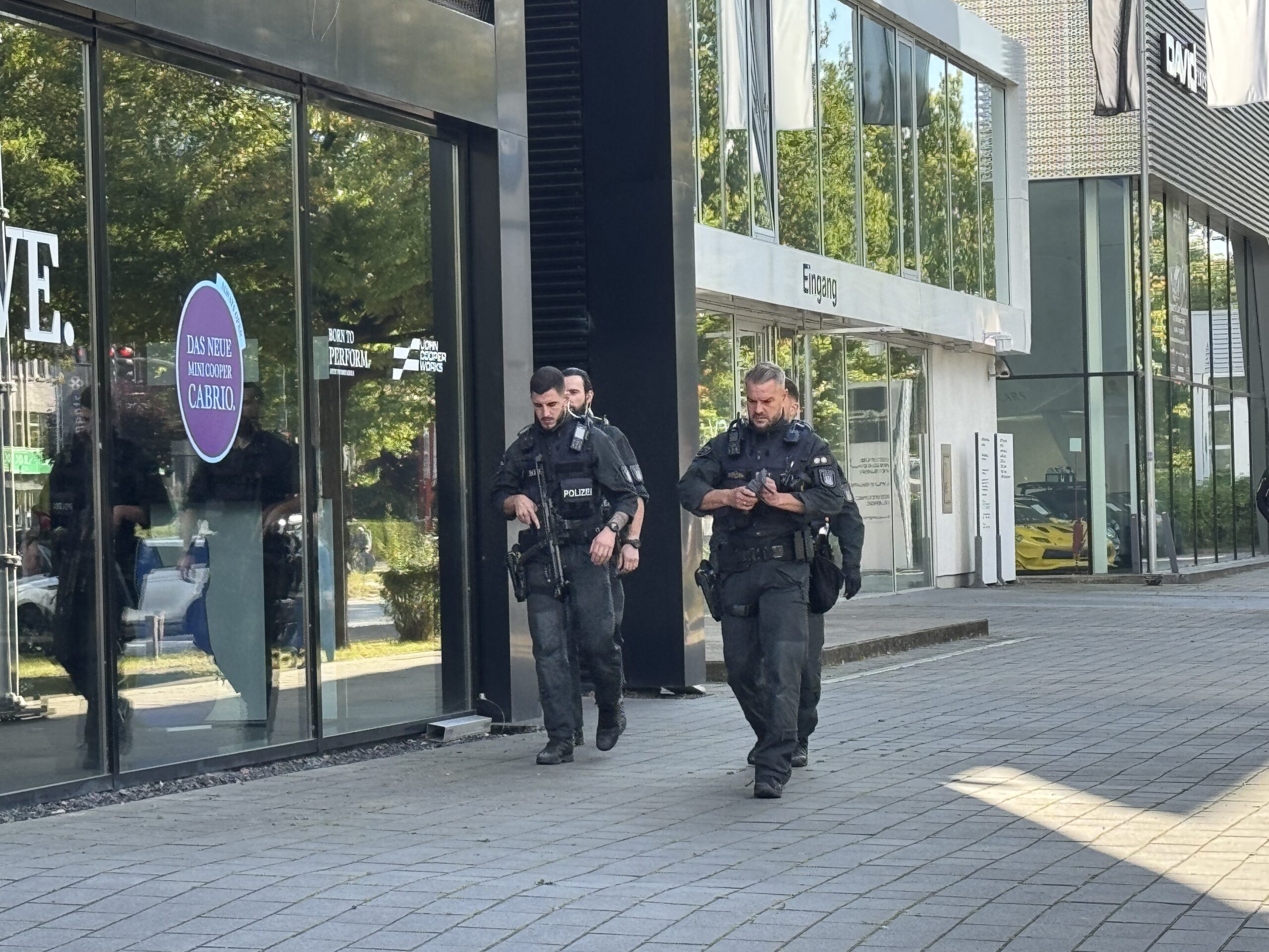 Vier Polizisten mit Maschinenpistolen gehen am Friedrich-Ebert-Damm entlang.