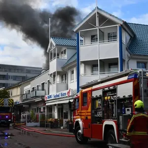 Dunkler Rauch steigt über einem Haus in den Himmel.