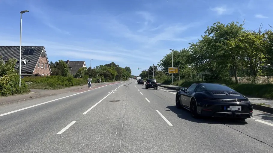Eine Straße in Westerland auf Sylt und rechts ein schwarzes Auto.