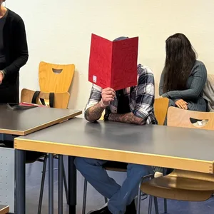 Der Angeklagte Mohanad G. sitzt mit einer roten Mappe vor dem Gesicht in Saal 1.07 des Amtsgerichtes St. Georg.