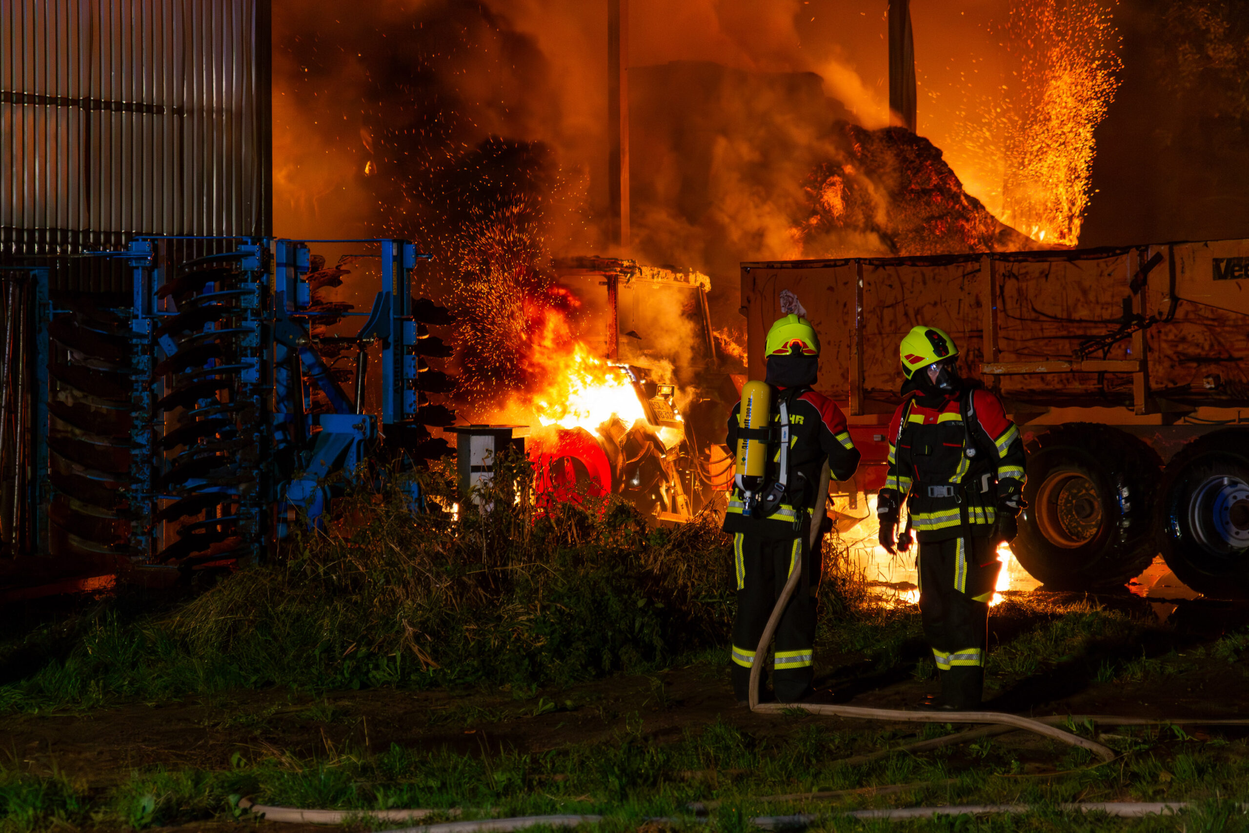 Einsatzkräfte vor der brennenden Lagerhalle.