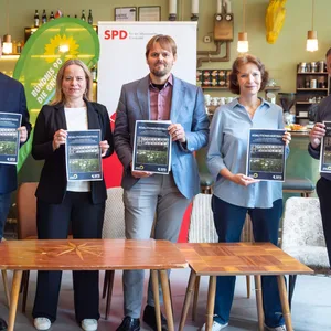 Mitglieder der SPD und Grünen stehen mit dem Koalitionsvertrag in der Hand.