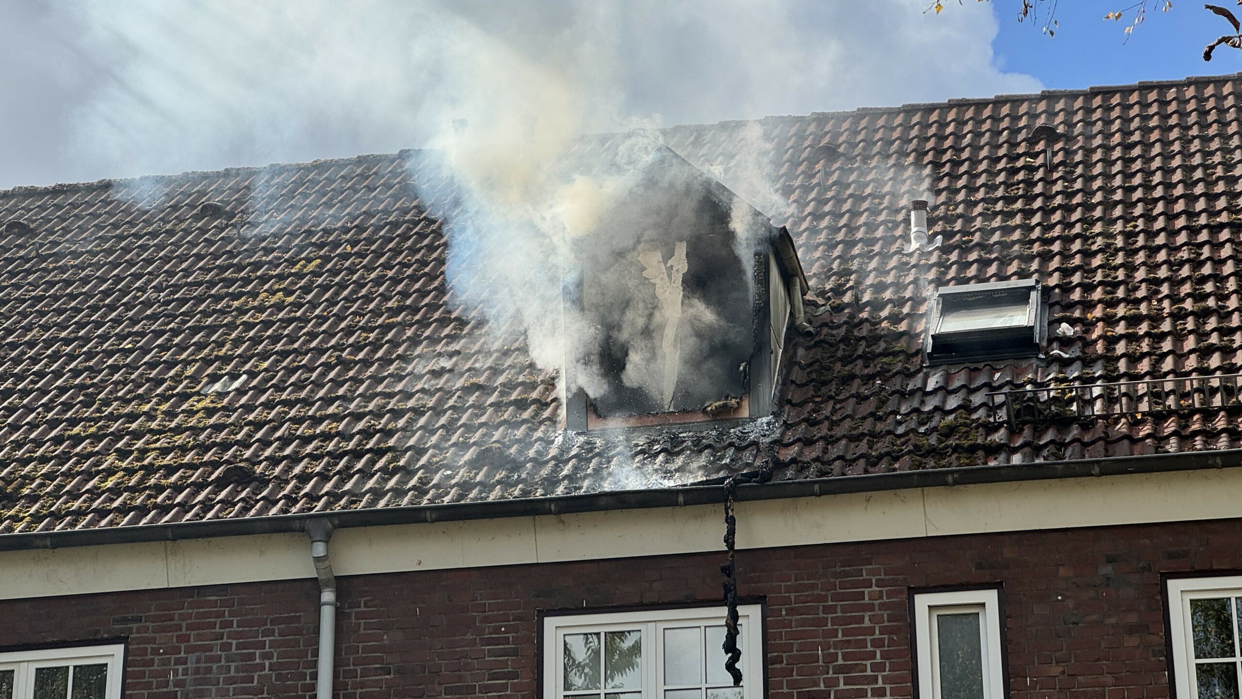 Dichter Rauch dringt aus dem Fenster der Dachgeschosswohnung.