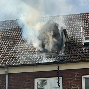 Dichter Rauch dringt aus dem Fenster der Dachgeschosswohnung.