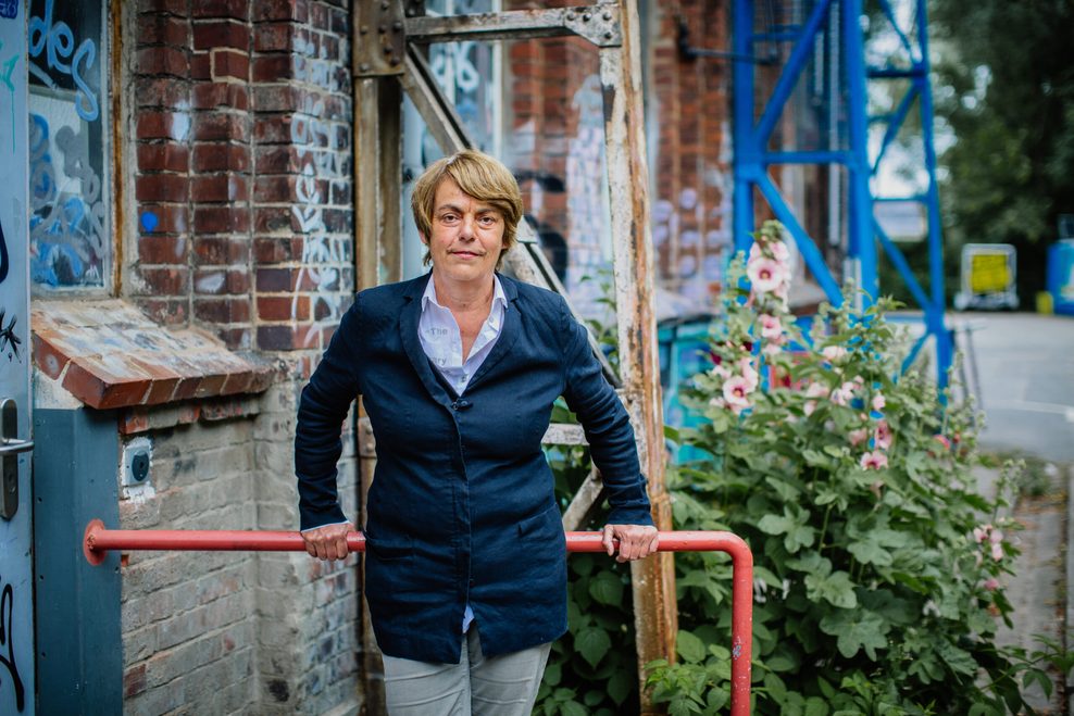 Amelie Deuflhard lehnt sich draußen an ein Geländer