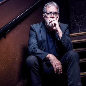 Wolfgang Trepper sitzt auf Treppenstufen