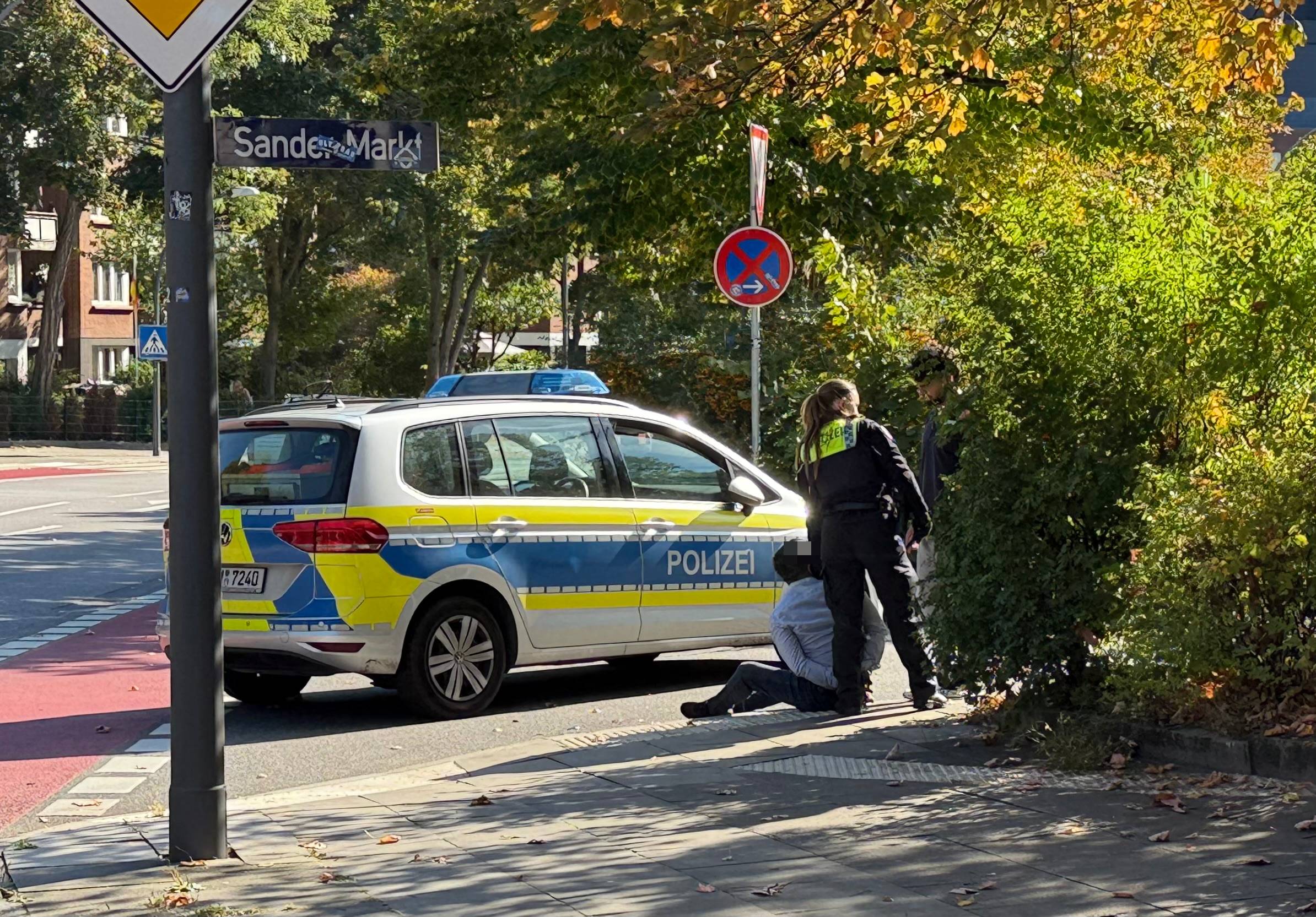 Eine Polizistin mit dem Beschuldigten am Sander Markt.