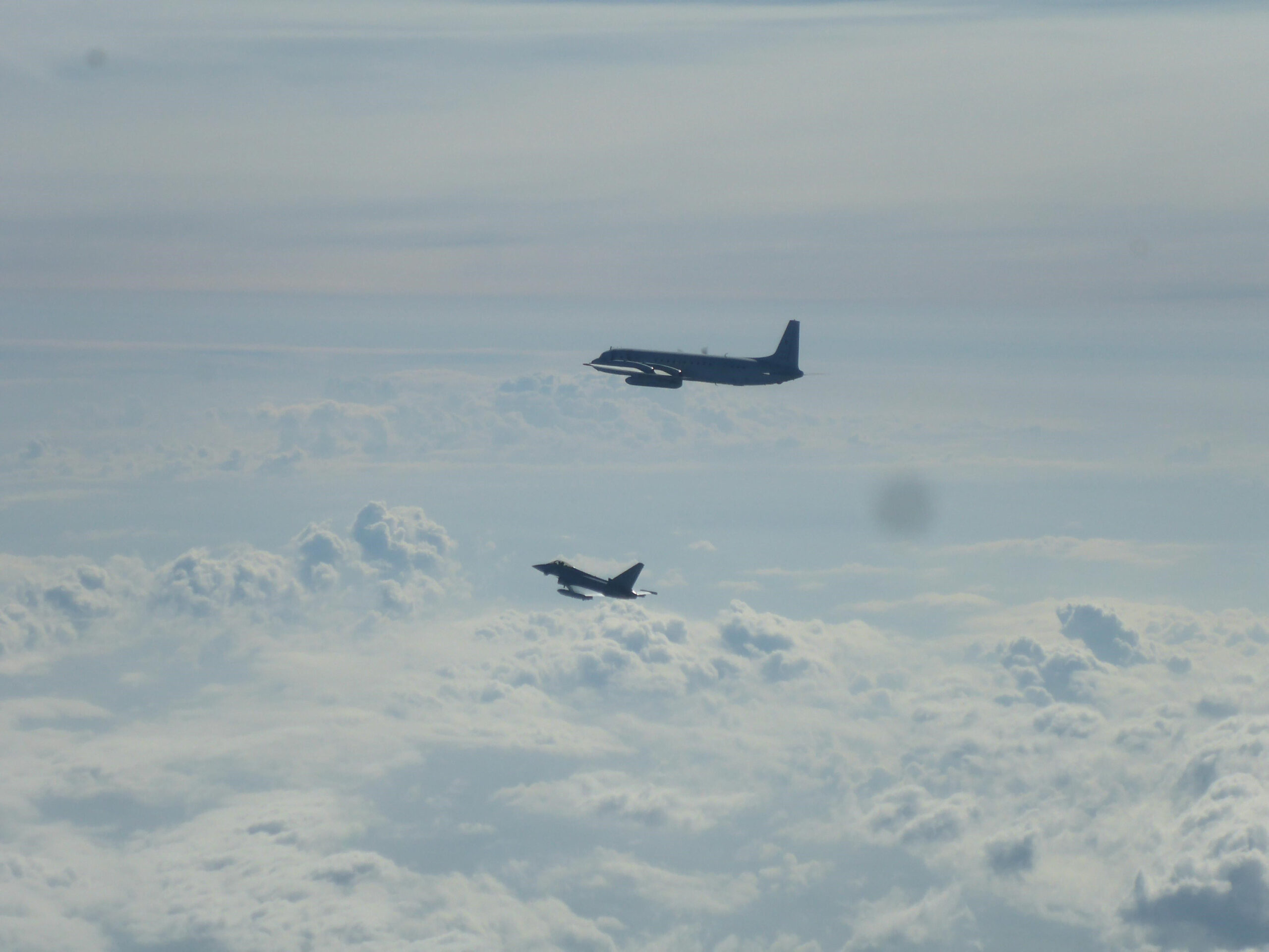 Ein Eurofighter und ein russisches Flugzeug fliegen über der Ostsee.
