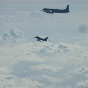 Ein Eurofighter und ein russisches Flugzeug fliegen über der Ostsee.