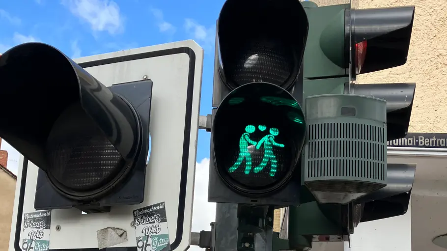 Eine grüne Ampel mit zwei Männern und einem Herz.