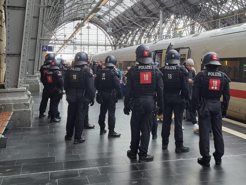 Polizisten in Montur stehen am Gleis