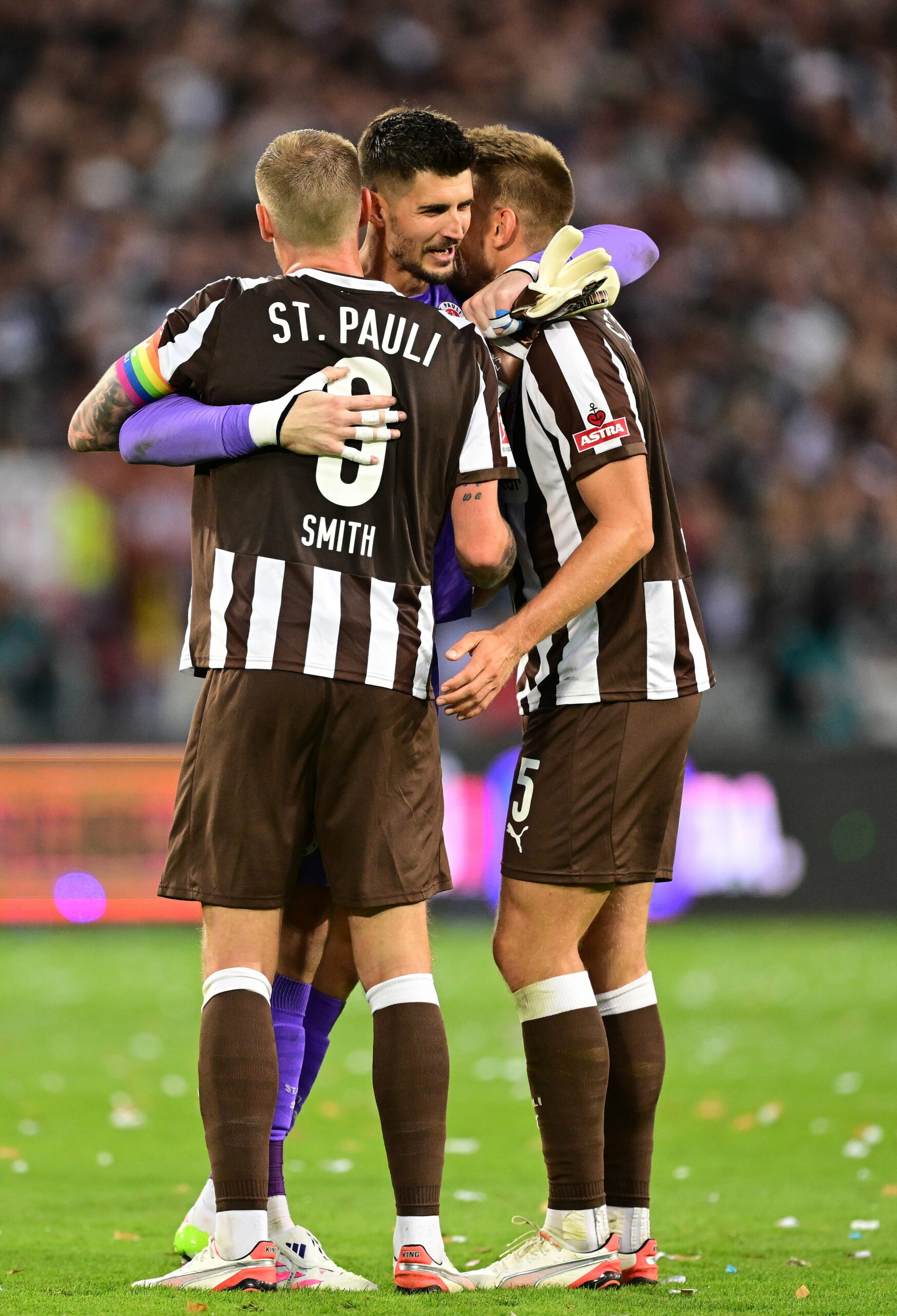 St. Pauli-Torhüter Nikola Vasilj umarmt Eric Smith und Hauke Wahl