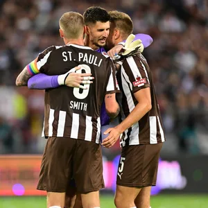 St. Pauli-Torhüter Nikola Vasilj umarmt Eric Smith und Hauke Wahl