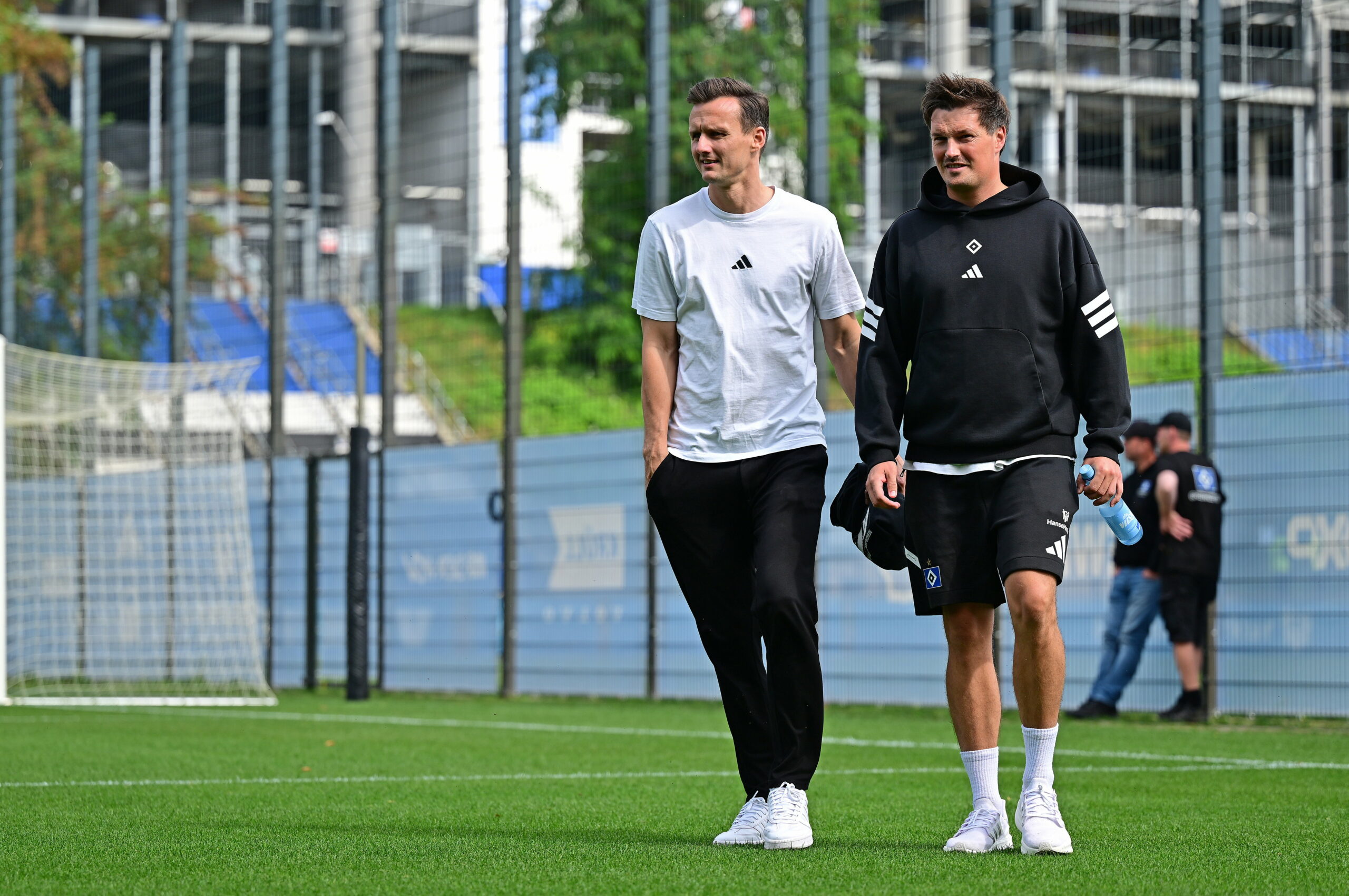 Claus Costa und Merlin Polzin gehen über den Trainingsplatz