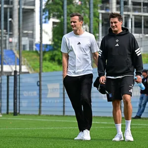 Claus Costa und Merlin Polzin gehen über den Trainingsplatz