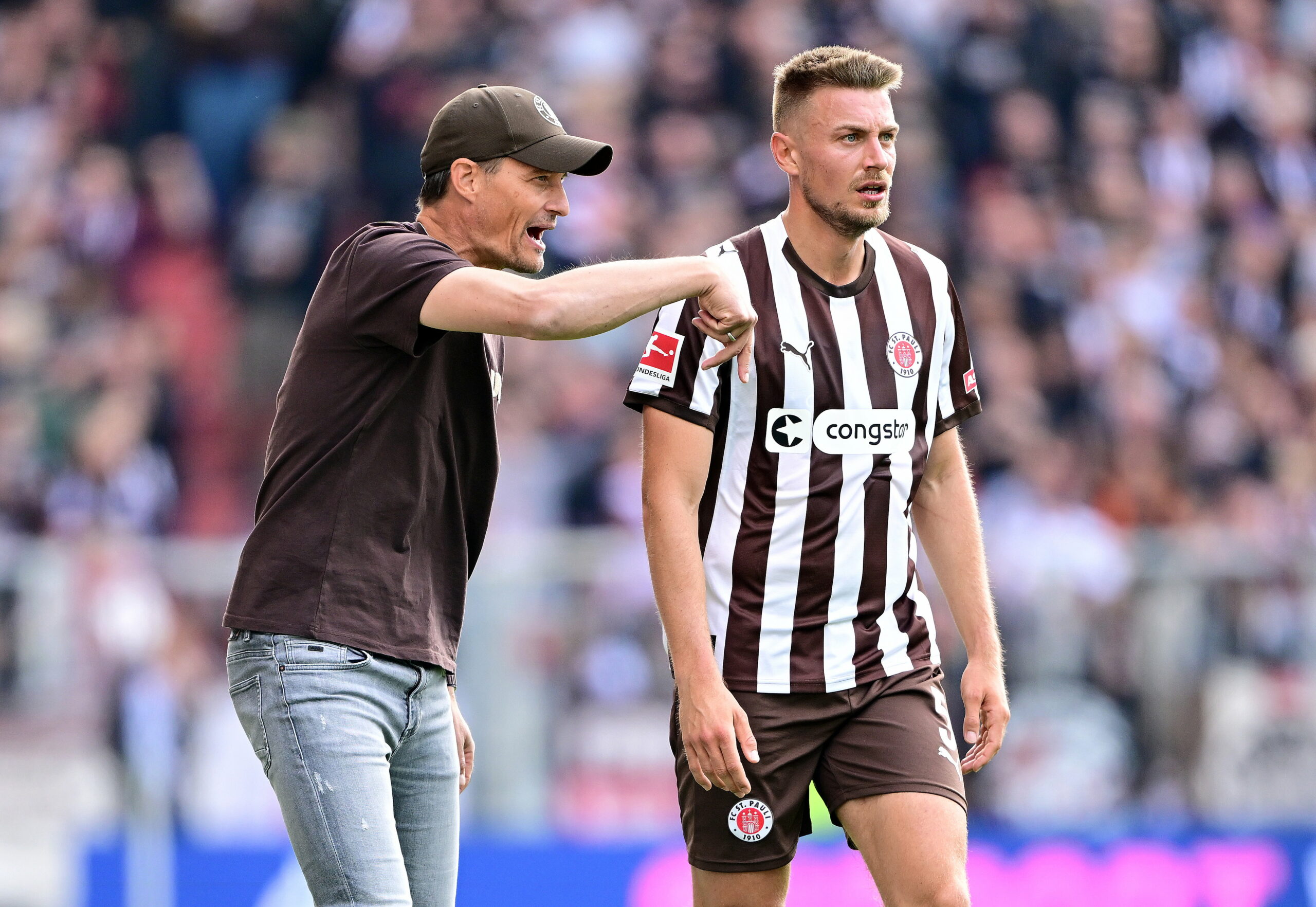 Alexander Blessin gibt Hauke Wahl Anweisungen im Spiel gegen Augsburg.