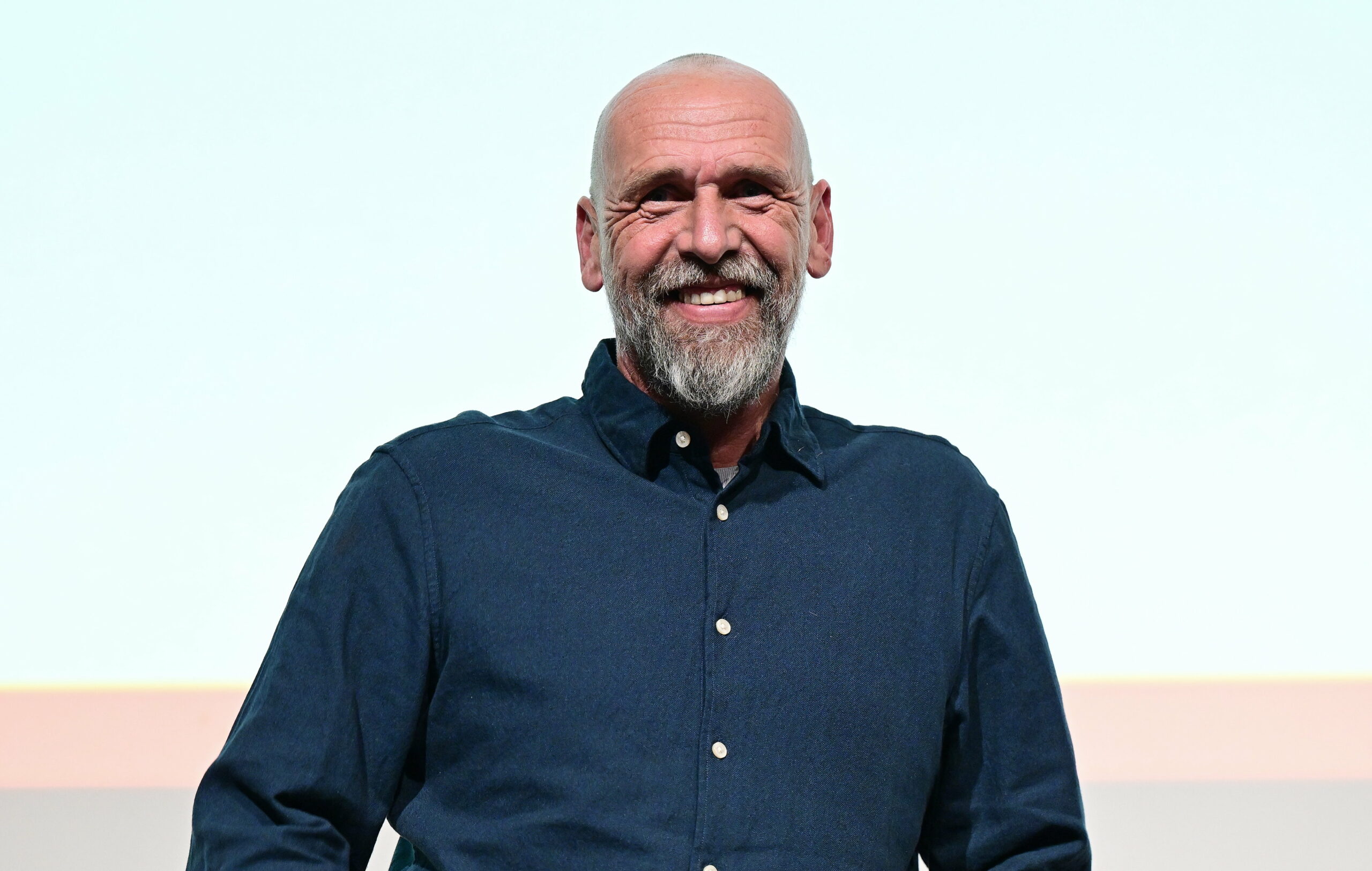 Holger Stanislawski lächelt auf der Bühne.