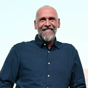 Holger Stanislawski lächelt auf der Bühne.