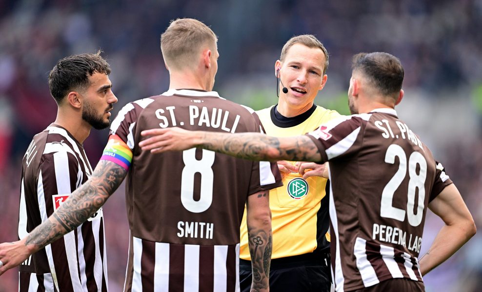 Schiedsrichter Martin Petersen diskutiert mit Danel Sinani, Eric Smith und Mathias Pereira Lage