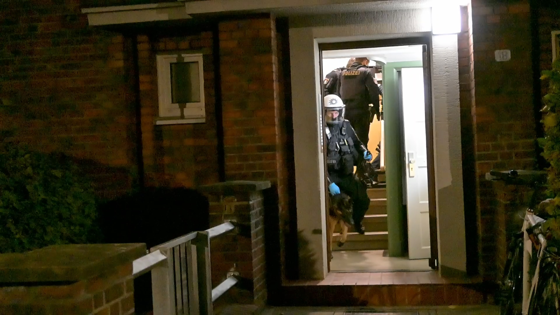 Die Polizeikräfte und ein Hund bei dem Einsatz in einem Heimfelder Mehrfamilienhaus.