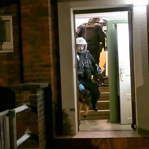 Die Polizeikräfte und ein Hund bei dem Einsatz in einem Heimfelder Mehrfamilienhaus.