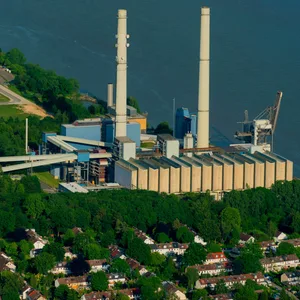 Luftbild vom Heizkraftwerk Wedel an der Elbe. Zu sehen sind die zwei Türme. Das Kraftwerk liegt direkt am Wasser und drum herum sind viele Bäume.