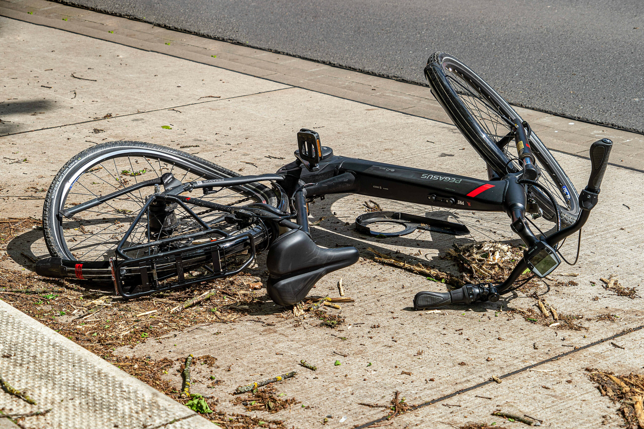 Ein Pedelec liegt nach einem Unfall stark beschädigt auf der Straße (Symbolfoto).