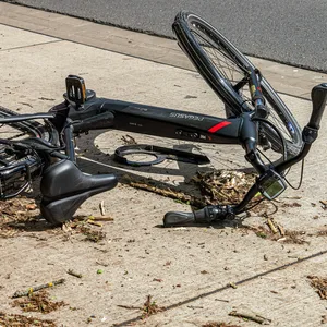 Ein Pedelec liegt nach einem Unfall stark beschädigt auf der Straße (Symbolfoto).